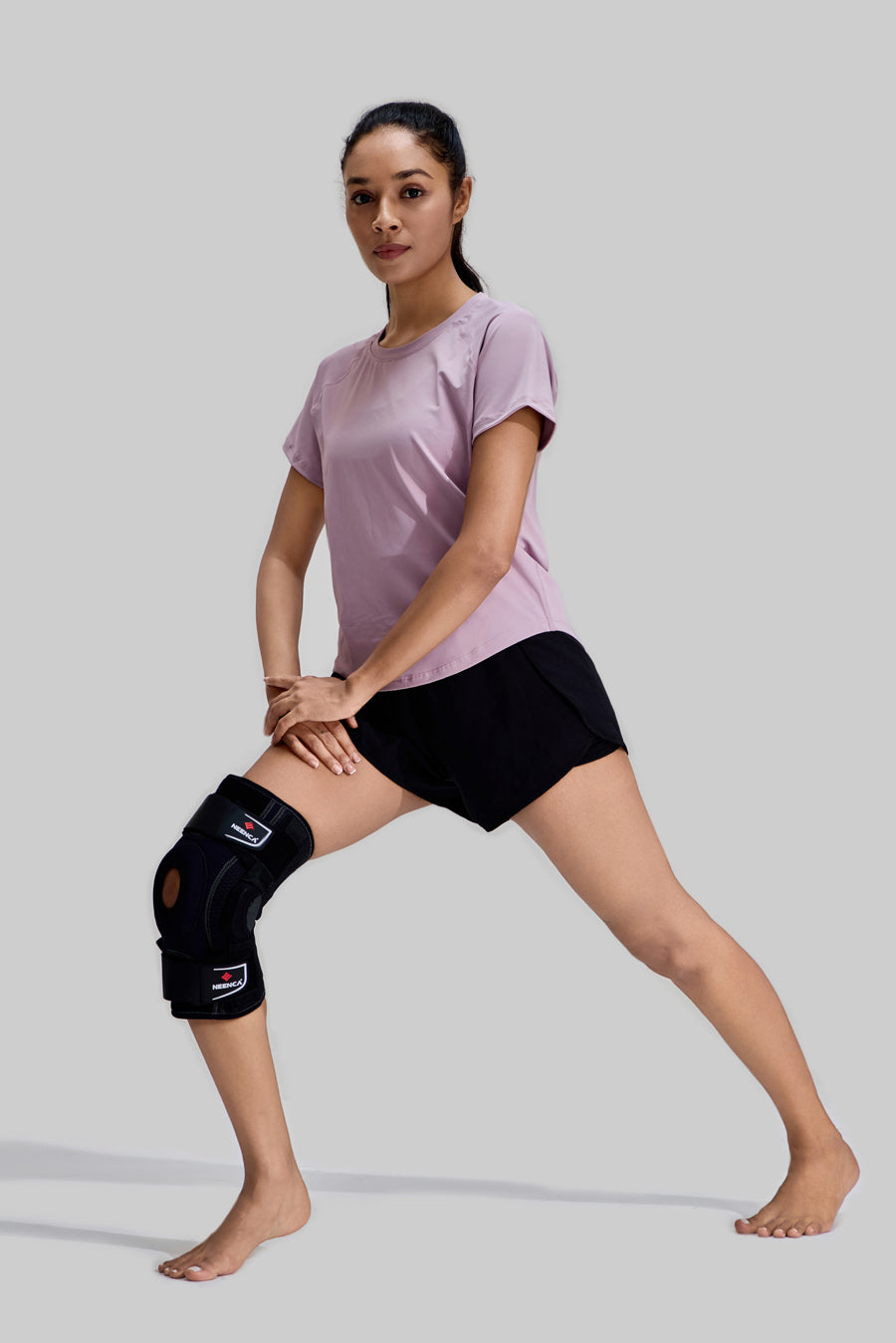 Female model performing lunges wearing NEENCA HX042/HX035 professional knee brace with side stabilizers