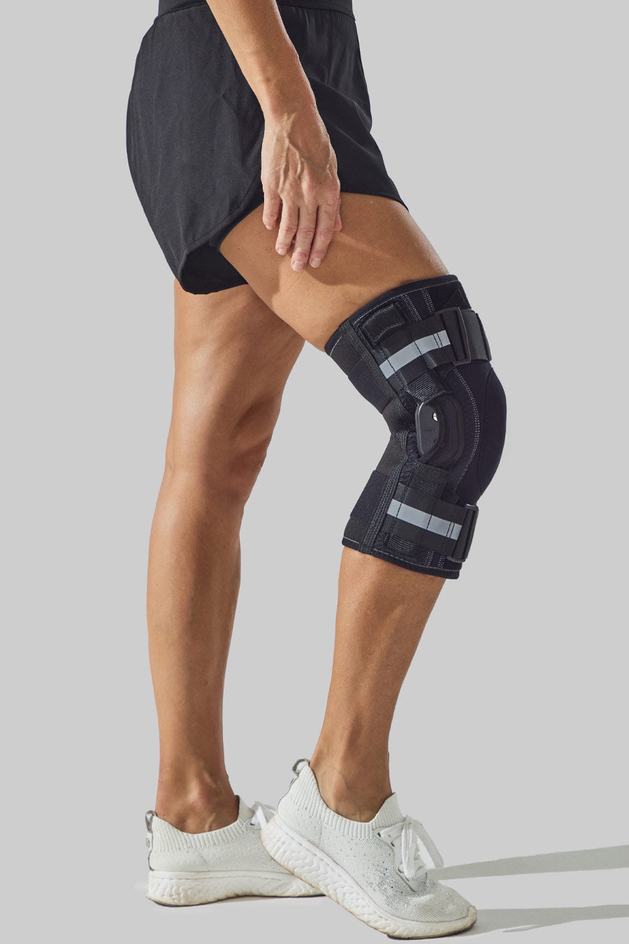Side view of a NEENCA hinged knee brace worn while bending the knee.