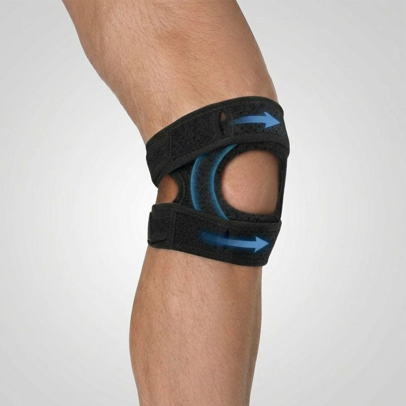 Black knee brace with blue accents on a person's knee against a light gray background
