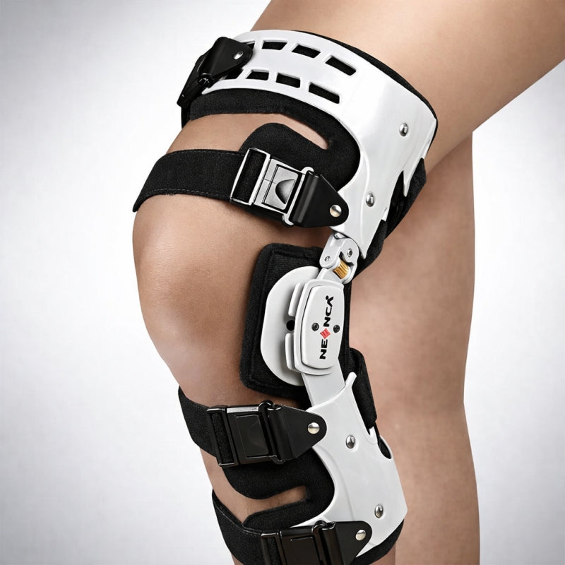 Knee brace with black straps on a person's knee, brand 'neenca' visible