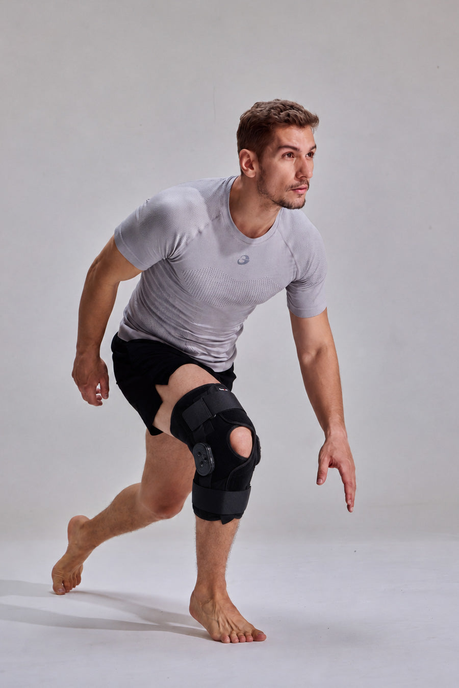 Person wearing NEENCA HX049 hinged knee brace while bending forward into a lunge.