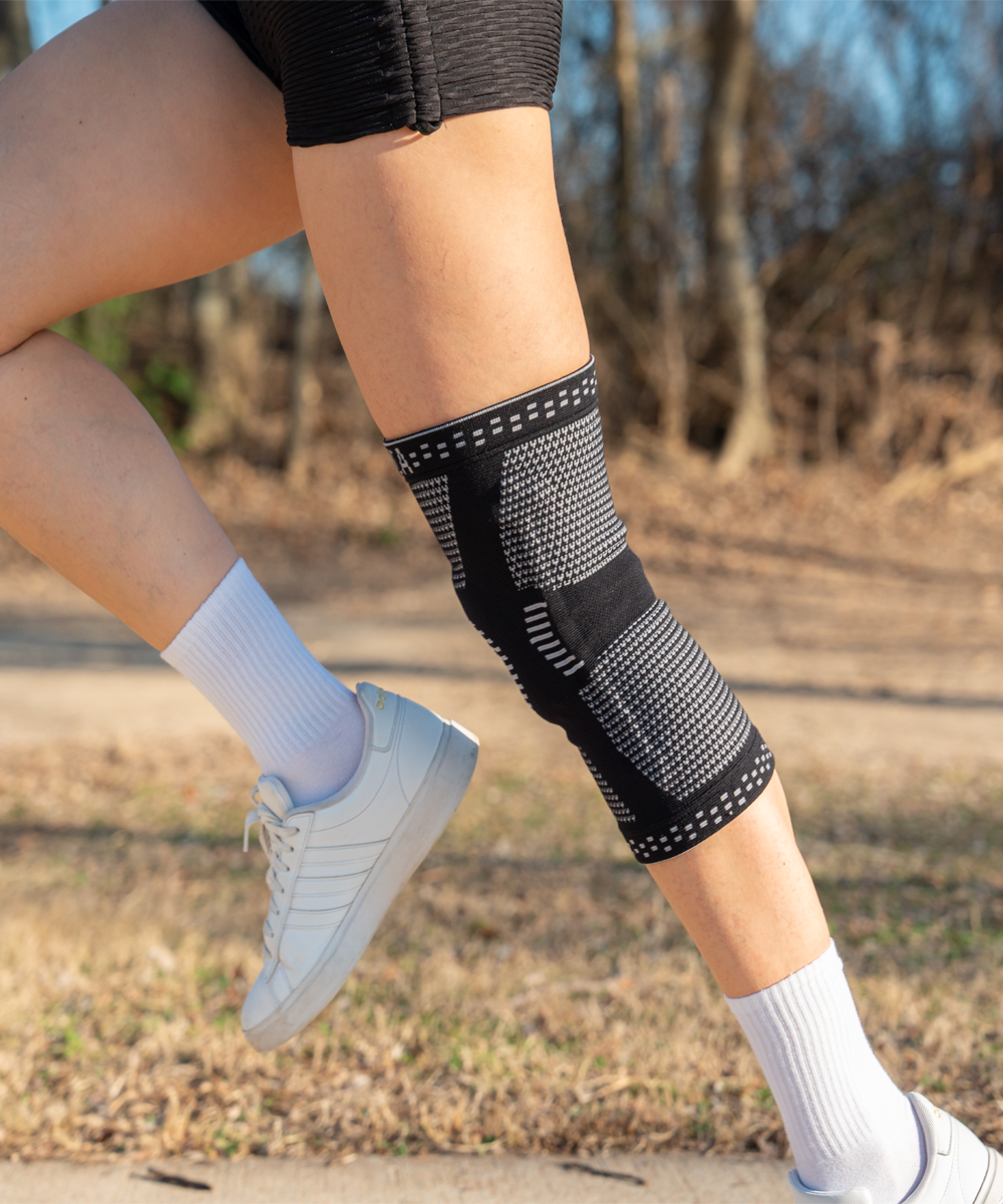 Person wearing neenca knee brace outdoors.