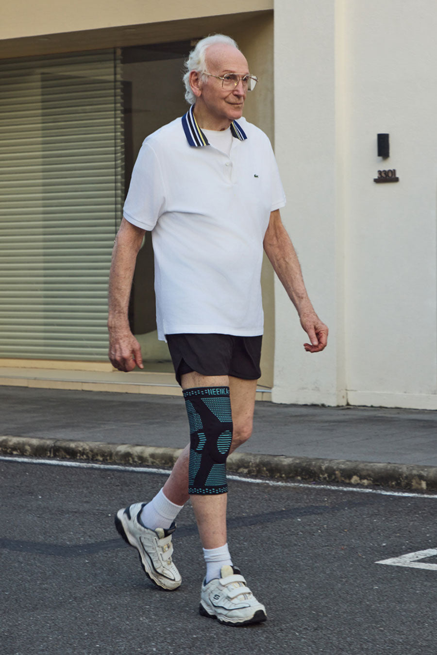 Senior man wearing a NEENCA knee brace while walking outdoors.