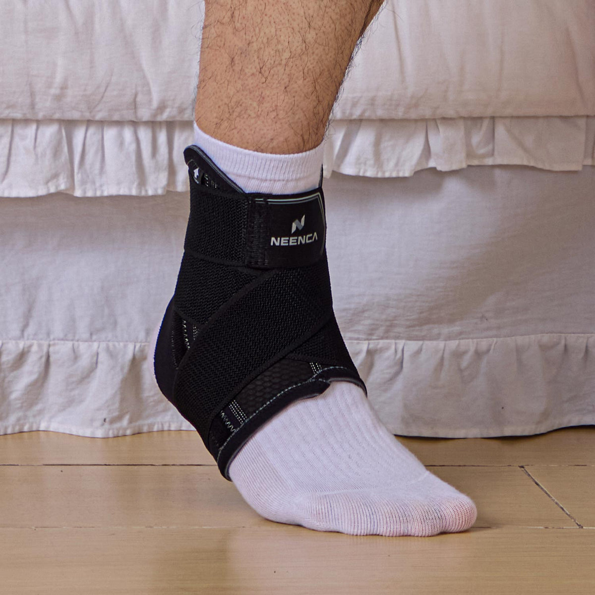 Person wearing a NEENCA ankle brace over a white sock.