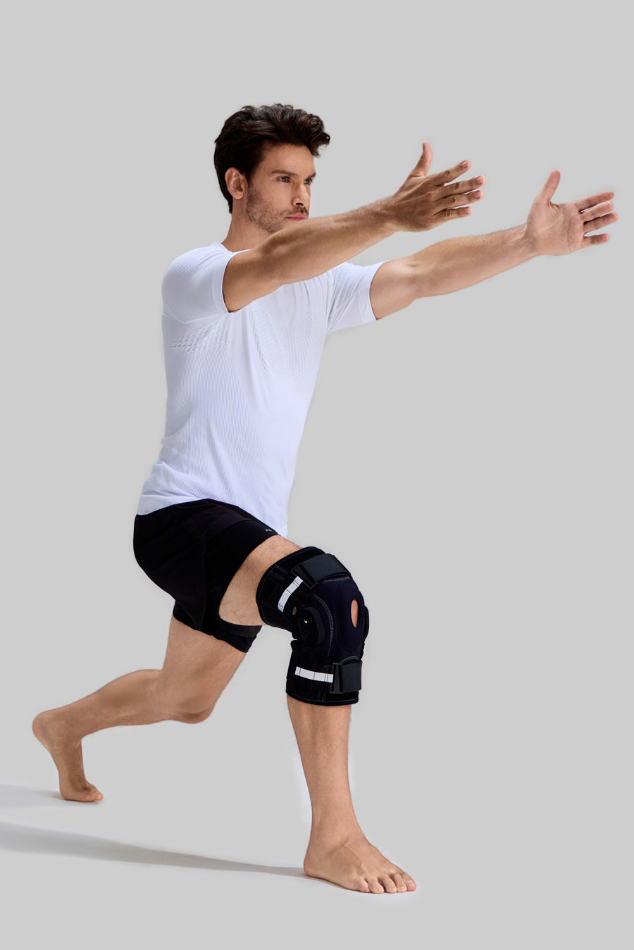 Male model performing forward lunges wearing NEENCA HX042/HX035 professional knee brace with side hinges and reflective straps