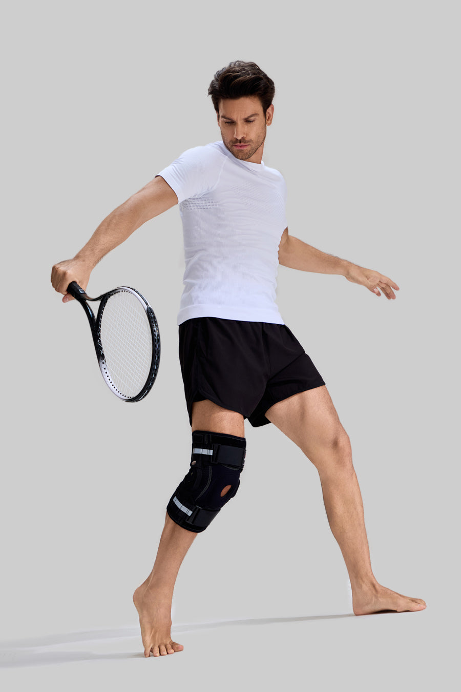 Male model playing tennis wearing NEENCA HX042/HX035 professional hinged knee brace for joint stability and sports protection