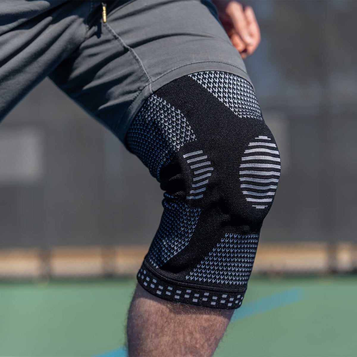 Man wearing a NEENCA knee brace during outdoor exercise.