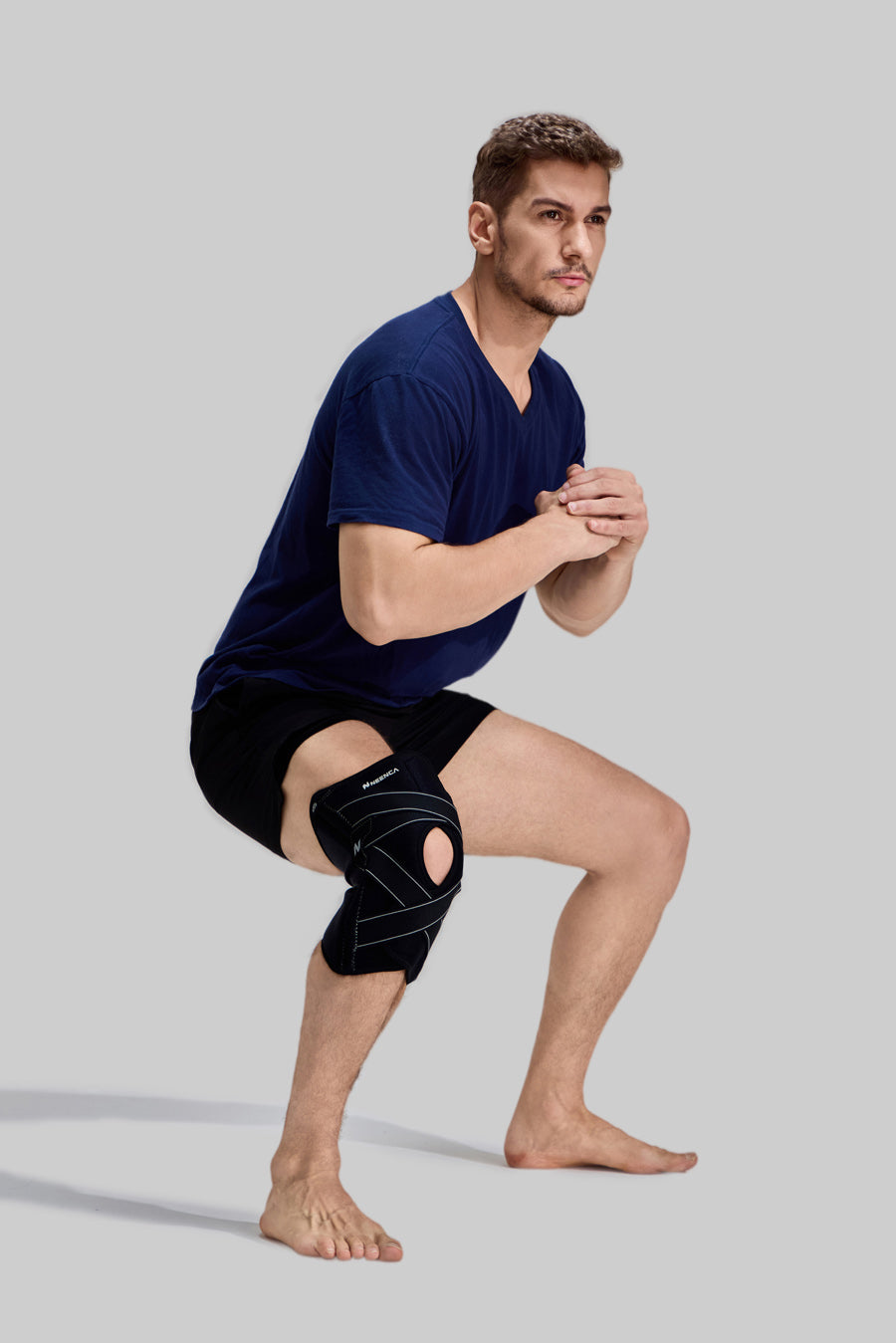 Side view of male model performing squats wearing black NEENCA HX024 professional sports knee support
